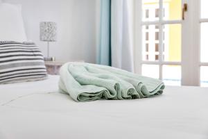 zielony ręcznik siedzący na łóżku w obiekcie Villa Aventura w mieście Kralendijk