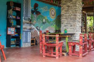 a table and chairs in a room with a mural at Kalitusi Nature Resort in Fort Portal