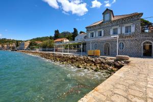 a building on the shore of a body of water at La Villa Lopud- Breakfast & Dinner Included in Lopud