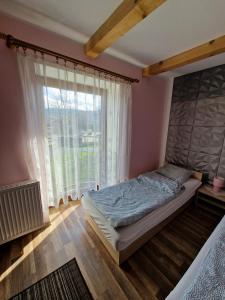 sypialnia z łóżkiem i dużym oknem w obiekcie Stara Kuźnia Radków w mieście Radków