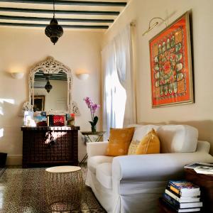 a living room with a white couch and a mirror at Número 9 in Medina Sidonia