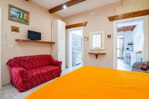 トッレ・ラピッロにあるVilletta Giorginaのベッドルーム1室(ベッド1台、赤いソファ付)