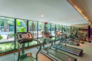 a row of treadmills in a gym with mirrors at 1Bedroom King Bed Fast Wifi Gym 00 Big Pool Checkin24h in Bangkok