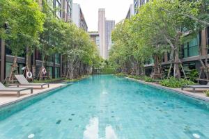 a swimming pool in a city with trees and buildings at 1Bedroom King Bed Fast Wifi Gym 00 Big Pool Checkin24h in Bangkok