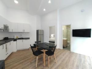 cocina y comedor con mesa y sillas en Apartamentos Vacceas by gaiarooms, en Salamanca