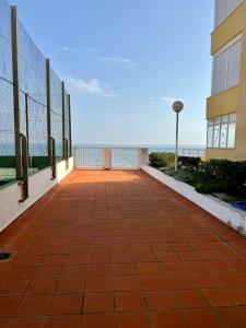 a walkway next to a building with the ocean in the background at Casa Schila in Tavernes de Valldigna
