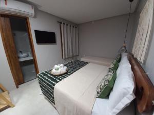 a bedroom with a large bed and a bathroom at Meu Dengo Pousada in Morro de São Paulo