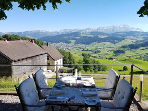einen Tisch und Stühle mit Bergblick in der Unterkunft Gasthaus Bären Schlatt in Appenzell