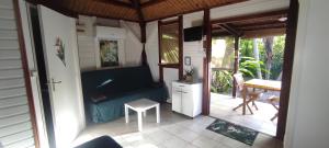 salon z kanapą i stołem w obiekcie bungalow tout confort avec piscine à 5 mn de la mer w mieście Saint-François