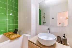 La salle de bains est pourvue d'un lavabo blanc et de carrelage vert. dans l'établissement L'élégance- Centre Historique- Confort- Netflix- Marché Frais et Local, à Grenoble