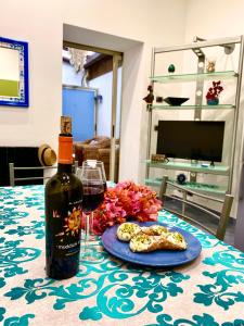 a bottle of wine and cookies on a table at Alpha22 Apartment in Giardini Naxos