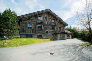 a large wooden house with a driveway in front of it at Chalet Mozart in Megève