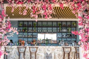 Riverside Garden Resort في كيرينيا: بار به زهور وردية معلقة من السقف