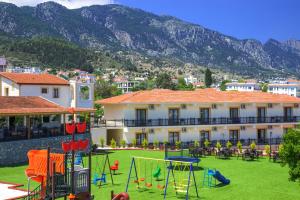 um resort com um parque infantil com montanhas ao fundo em Riverside Garden Resort em Kyrenia