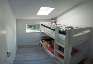 um beliche branco num quarto com uma janela em Bright summer house close to the beach and water em Holbæk