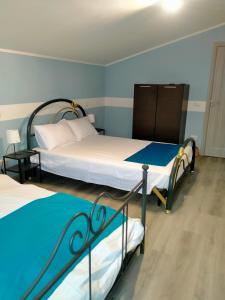 2 łóżka w pokoju z niebieskimi ścianami w obiekcie Maramureș plai cu flori w mieście Ocna Şugatag