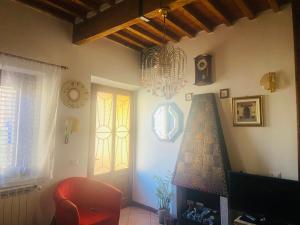 un salon avec un lustre et un fauteuil rouge dans l'établissement Casa Fiorina, à Barga