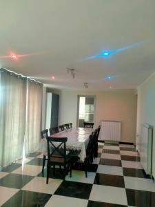 a dining room with a table and chairs on a checkered floor at Maramureș plai cu flori in Ocna Şugatag +30 photos