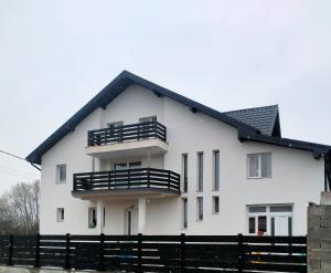 a white house with a black roof at Maramureș plai cu flori in Ocna Şugatag