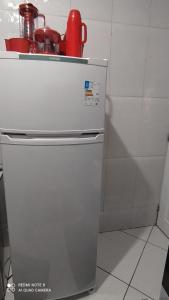 a white refrigerator in a kitchen next to a wall at Casa Completa com Garagem a 400mts da basilica in Aparecida +9 photos