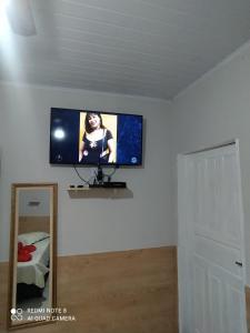 a flat screen tv on a wall in a bedroom at Casa Completa com Garagem a 400mts da basilica in Aparecida