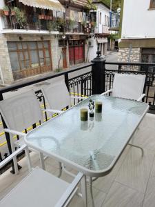 y balcón con mesa de cristal y sillas. en Summer Life, en Panayia