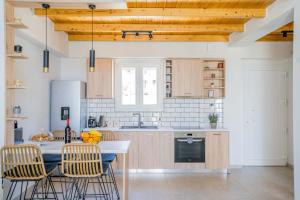 a kitchen with a table and chairs in a room at Elianthos Luxury Villas in Tsoukalades