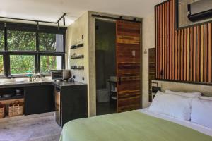 een slaapkamer met een bed en een keuken met een wastafel bij LOTE4 - LGBTQ Studios in Playa del Carmen
