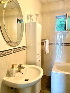 a white bathroom with a sink and a mirror at Sea view country house in Prčanj