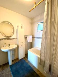 y baño con lavabo, bañera y espejo. en Sea view country house en Prčanj