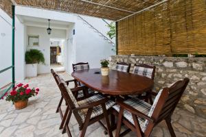 a wooden table and chairs on a patio at Guesthouse Aurora in Hvar