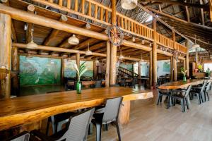 comedor grande con mesas y sillas de madera en Arca Tayrona Restaurant & Hostal en Santa Marta