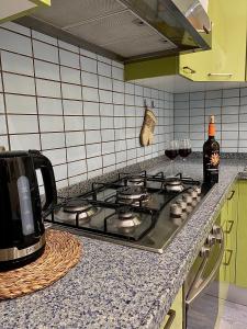 a kitchen counter with a stove top with a bottle of wine at Alpha22 Apartment in Giardini Naxos