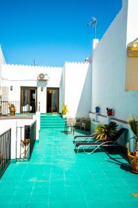 un patio con azulejos verdes en un edificio blanco en Marbella Village, en Marbella