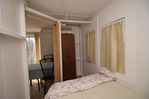 a small bedroom with a bed and a dining room at 1 Bdrm Country cottage #5 - Rosewood Cottages in Southampton