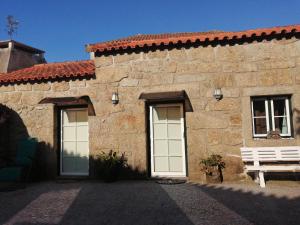 a stone building with two doors and a bench at São Braz Terrace in Landim