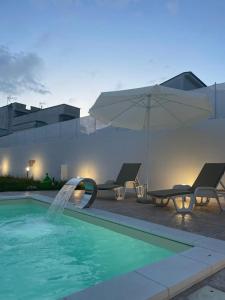 uma piscina com uma fonte com cadeiras e um guarda-sol em L’Arte di Vittorio Bed and Breakfast em Racale