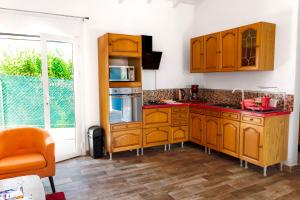 a kitchen with wooden cabinets and red counter tops at Les gites du plateau de gissac in Sainte-Anne