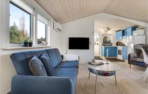 ホーフブルグにあるGorgeous Home In Hovborg With Kitchenのリビングルーム(青いソファ、テーブル付)