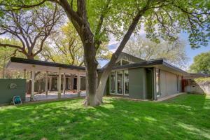 a green house with a tree in the yard at Mid-Century Modern Home with Fire Pit and Gas Grill! in Amarillo