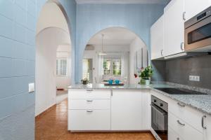 una cucina con armadi bianchi e pareti blu di Beautiful house with sea views and private pool a Torrevieja
