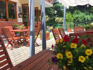 a wooden table with a bouquet of flowers on a patio at Hotel Ede in Caramanico Terme