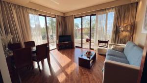 uma sala de estar com um sofá, uma mesa e uma televisão em Luxury Dreamland Oasis Apartments em Chakvi