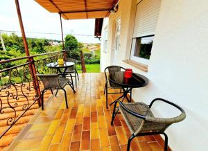 a balcony with tables and chairs on a porch at APP & Beauty Loza in Zambratija