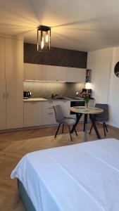 a room with a bed and a table and a kitchen at Apartament Sienkiewicza 22 in Zamość +7 photos