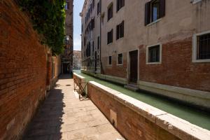 une allée vide avec des bâtiments et un canal dans l'établissement Rialto Boutique Apartment, à Venise