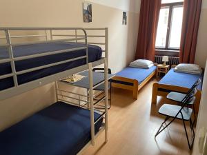 Pokój z 2 łóżkami piętrowymi i krzesłem w obiekcie Hostel EMMA w Pradze +37 zdjęć