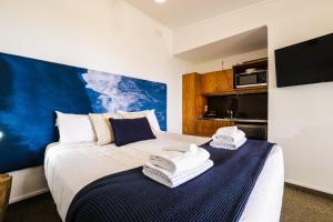 a bedroom with a bed with towels on it at Tasman Holiday Parks - Waihi Beach in Waihi Beach