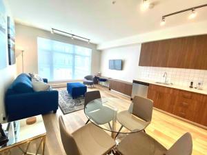 a living room with a blue couch and chairs at Perfect Brand New Condo In The Heart of Sidney in Sidney