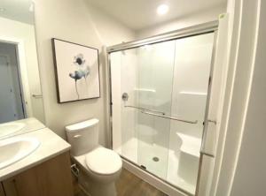 a bathroom with a shower and a toilet and a sink at Perfect Brand New Condo In The Heart of Sidney in Sidney